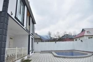 a house with a swimming pool next to a white fence at Gabala White House in Gabala