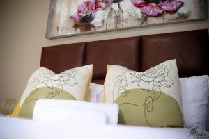 a bed with two pillows with flowers on it at Savanna Buffalo Guest House in eMalahleni