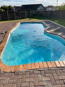 a swimming pool with blue water in a backyard at Savanna Buffalo Guest House in eMalahleni