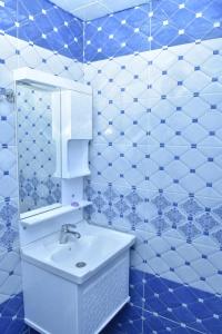 a blue and white bathroom with a sink and mirror at Gabala White House in Gabala