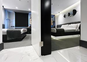 a bedroom with two beds and a mirror at MELLDAY HOTEL 