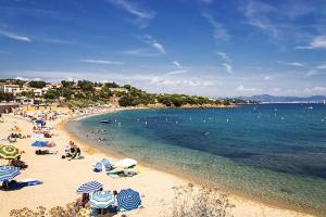 einen Strand mit Menschen und Sonnenschirmen und dem Meer in der Unterkunft Appartements Supérieurs in Saint-Aygulf