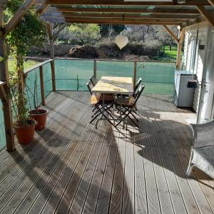 a wooden deck with a table and chairs on it at Casa das Amoras in Santo António das Areias
