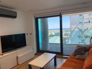 un soggiorno con grande TV a schermo piatto e divano di Apt with pools, spa, views and central location a Gibilterra