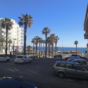 a parking lot with palm trees and a building at Gallipoli Lungomare 10 in Gallipoli