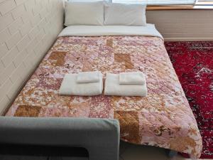 a bed with two towels on top of it at Tuggeranong Short Stay #09 Sleeps 4 in Tuggeranong