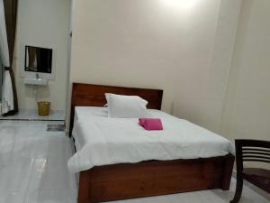 a bedroom with a bed with a pink towel on it at Ida Guest House & Restaurant in Bukit Lawang