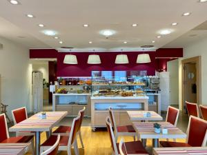 un restaurante con mesas y sillas y una cocina en Best Western Palace Inn Hotel, en Ferrara