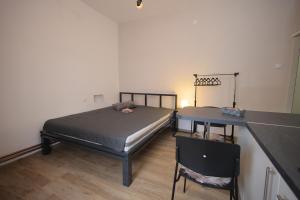 a bedroom with a bed and a table and a desk at Soho in Vrnjačka Banja