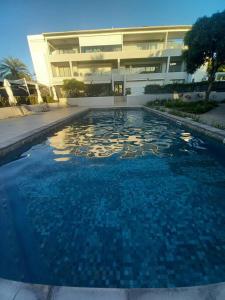 a large swimming pool in front of a building at Beachfront Apartment in Tamarin