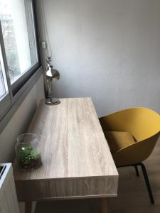 einen gelben Stuhl und einen Holztisch mit einem gelben Stuhl in der Unterkunft Les jardins du Paradis in Marseille