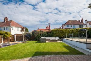 a garden with a lawn in the middle of a house at Lovely 3 bedroom home in Rhos on Sea in Llandrillo-yn-Rhôs