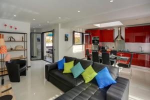 Appartements Supérieurs في سانت أي جولف: غرفة معيشة مع أريكة سوداء مع وسائد ملونة
