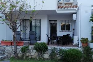 ein weißes Haus mit einem Tisch und Stühlen in der Unterkunft Beautiful apartment in La Carihuela, Torremolinos in Torremolinos