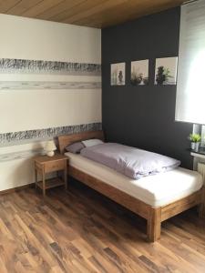 1 cama en un dormitorio con suelo de madera en Ferienwohnung am Wiehengebirge, en Hüllhorst