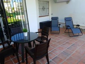 eine Terrasse mit Stühlen, einem Tisch und Stühlen in der Unterkunft Beautiful apartment in La Carihuela, Torremolinos in Torremolinos