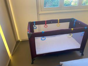 a crib with colorful beads on it in a room at luxury apartment in Pesaro