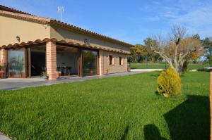una casa con un césped verde delante de ella en Mas Piua, en Girona