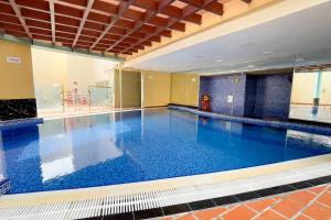 a large swimming pool with blue water in a building at Veluxa - Large and Stylish 1 Bed in JLT! in Dubai