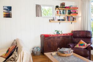 a living room with a couch and a chair at Nigel's Crib - Coopers Beach Holiday Home in Coopers Beach