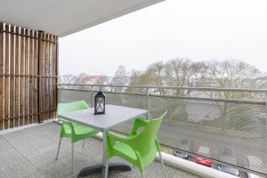 - un balcon avec une table et des chaises dans l'établissement Zenao Appart'hôtels Strasbourg, à Strasbourg