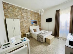 Un dormitorio con una cama blanca y una pared de ladrillo. en Made in Ortigia Apartments, en Siracusa