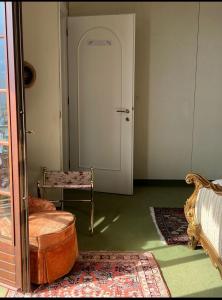 um quarto com uma porta, uma cadeira e uma mesa em Residenza Le Magnolie em Verbania