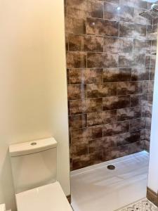 a bathroom with a shower with a toilet at BlueStone-Hot Tub-Woodlandlodges-Pembrokeshire-Tenby in Carmarthen +5 photos