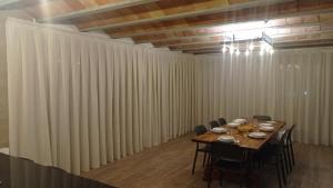 una sala de conferencias con mesa, sillas y cortinas en Mas Piua en Girona