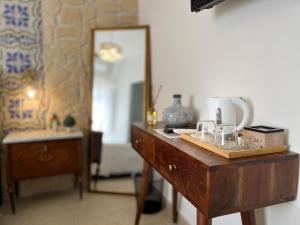 uma cómoda de madeira com um espelho e uma mesa com um lavatório em Incanto Siciliano em Noto