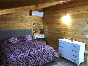a bedroom with a bed and a wooden wall at Wooden Guest House 
