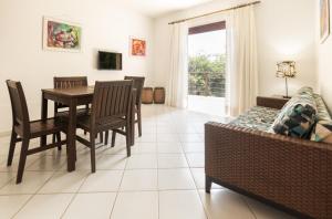 sala de estar con mesa, sillas y sofá en Apartamento na cobertura visual Jardim Brisas do Amor, en Pipa