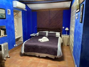 Un dormitorio azul con una cama con toallas. en Casa Gallinera en Benissiva