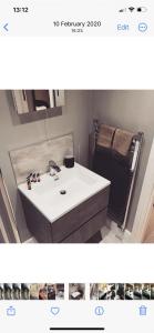 La salle de bains est pourvue d'un lavabo blanc et d'un miroir. dans l'établissement The Station Restaurant & Bar, à Doncaster