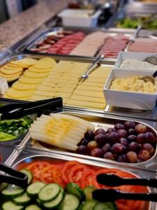 a buffet filled with different types of cheese and vegetables at Rainbow Apartments 1 in Kraków
