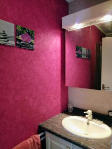 uma casa de banho com um lavatório e uma parede rosa em Maison plain pied avec jardin, terrasse et veranda em Cognac