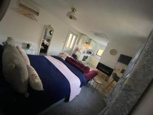 um quarto com uma cama com um cobertor azul e branco em The Wee house at the cottage em Annan