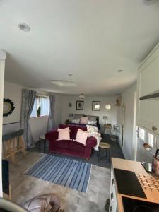 sala de estar con sofá rojo y cama en The Wee house at the cottage, en Annan