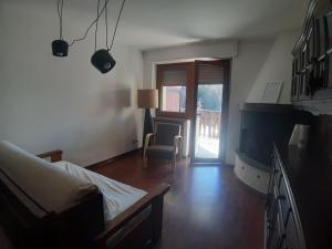 a bedroom with a bed and a chair and a window at Appartamento con vista panoramica in Sauze dʼOulx