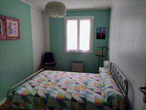 um quarto com uma cama com uma colcha colorida em Maison plain pied avec jardin, terrasse et veranda em Cognac