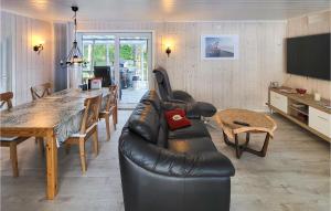 a living room with a black leather couch and a table at Stunning Home In Rde With Kitchen in Råde
