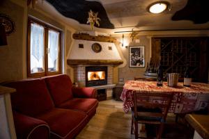 a living room with a couch and a fireplace at Chalet Relax Tra Le Vigne in Forni di Sotto