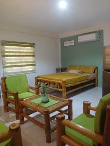 um quarto com uma cama, uma mesa e cadeiras em Michaels Homestay - Farm Villa nr Patar Beach & Bolinao Falls em Bolinao