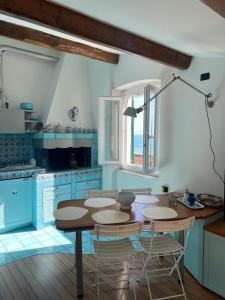 een keuken met een tafel en stoelen in een kamer bij Elegant apartment with sea view in Monterosso al Mare