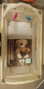 a teddy bear is sitting in a bed at La Buona Stella Apartment in Pistoia