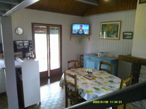 a room with a table and a kitchen with a television at a l'orée de tronçais in La Perche