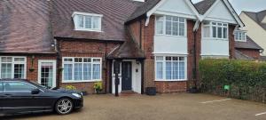 a black car parked in front of a brick house at Hampton Lodge En-Suite Rooms with Free Parking in Stratford-upon-Avon