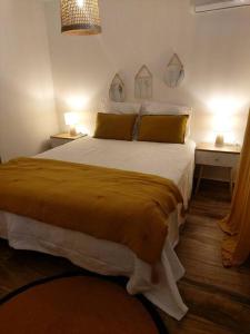a bedroom with a large bed with yellow sheets at Villa Tamara in Le Pourpier
