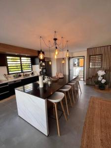 a kitchen with a large island with bar chairs at Villa Tamara in Le Pourpier