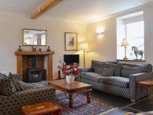 sala de estar con sofás y chimenea en Stable Cottage - Beaufort Estate, en Belladrum